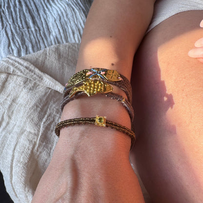 Close-up of a wrist wearing multiple bracelets with a blurred background
