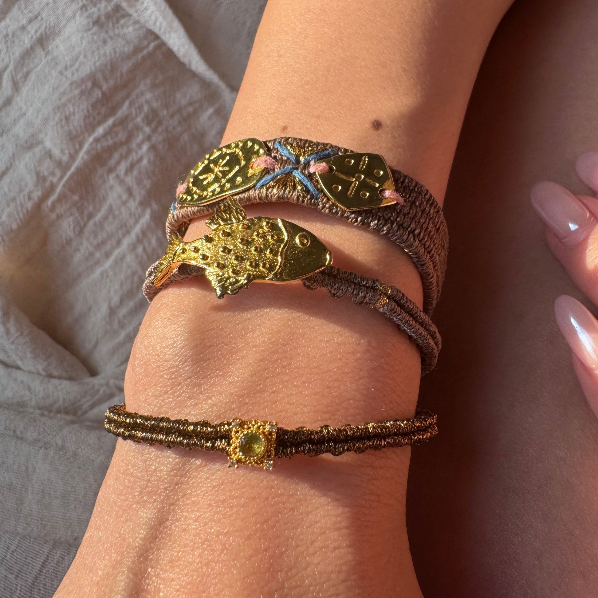 Close-up of a wrist wearing multiple bracelets with intricate designs.