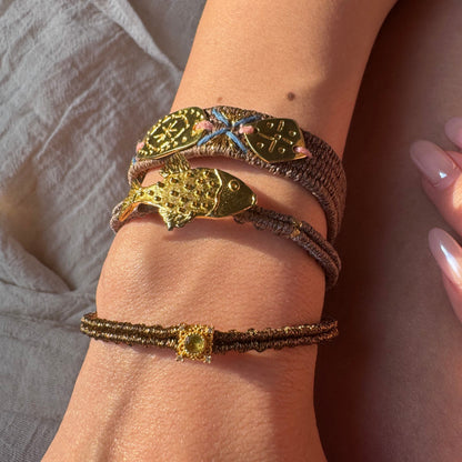 Close-up of a wrist wearing multiple bracelets with intricate designs.