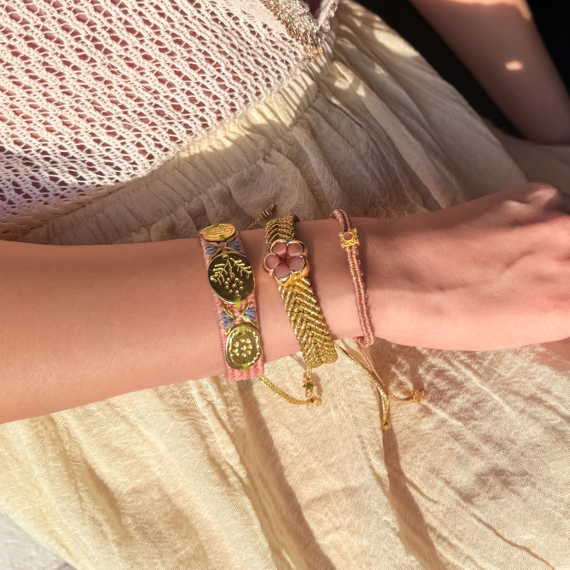 Close-up of a person's wrist wearing multiple colorful bracelets on a light background