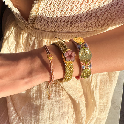 Close-up of a wrist wearing multiple colorful bracelets with a neutral background
