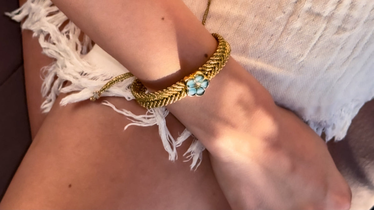 Gold bracelet with a turquoise stone on a person's wrist 